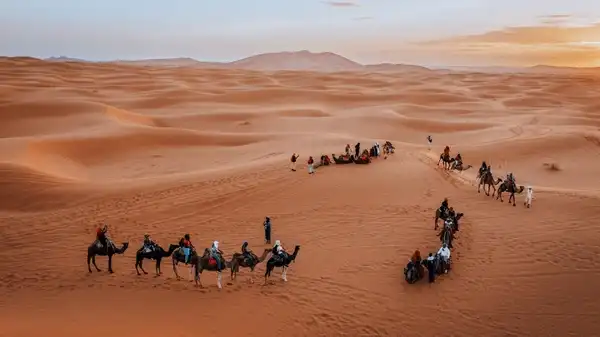 Travelers exploring the Merzouga dunes on a 5-day Marrakech desert tour